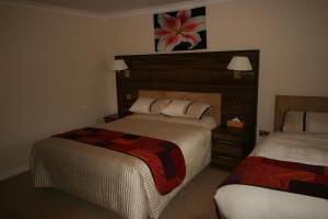 a hotel room with two beds and a headboard at The Plough Inn in Pocklington