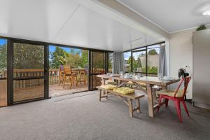 a dining room with a table and chairs and a patio at Point Retreat - Lake Rotoiti Holiday Home in Rotoiti