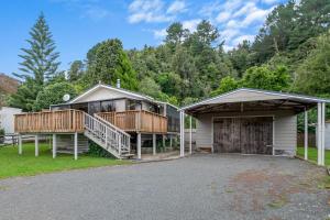 Rotoiti的住宿－Point Retreat - Lake Rotoiti Holiday Home，一个带两个甲板和一个车库的房子