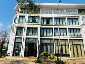 um grande edifício branco com janelas e plantas em UTEY Hotel em Siem Reap