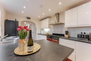 a kitchen with a bottle of wine and flowers on a counter at 9 Morris Street in Sheringham