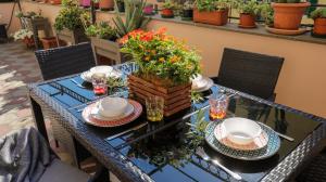 a blue table with plates and flowers on it at Sole, Terrazza, Centro città e Wi-Fi veloce! in Genova