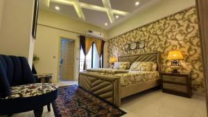 a bedroom with a bed and a lamp and a chair at Sunnyvale Defense Executive Apartments 913 in Islamabad