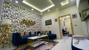 イスラマバードにあるThe Realtors Inn 1 BDR Apartment DHA 2のリビングルーム(青いソファ、壁付)