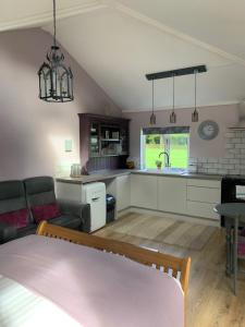 eine Küche und ein Wohnzimmer mit einem Sofa und einem Tisch in der Unterkunft The Snuggery Broadclyst in Exeter