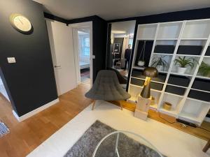 a living room with a chair and a clock on a wall at Stylish flat next to King's Cross Station in London