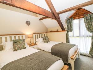 a bedroom with two beds and a window at The Hawthorns in South Molton