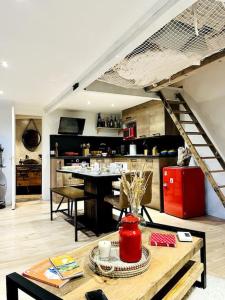 a living room with a staircase and a kitchen at Chalet cosy avec vue dégagée in Métabief