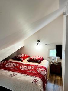 1 dormitorio con 1 cama grande con almohadas rojas en Chalet cosy avec vue dégagée en Métabief