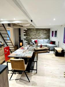een woonkamer met een tafel en een bank bij Chalet cosy avec vue dégagée in Métabief