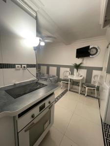 cocina con fregadero y mesa con sillas en Chambre de luxe 95 Grise, en Deuil-la-Barre