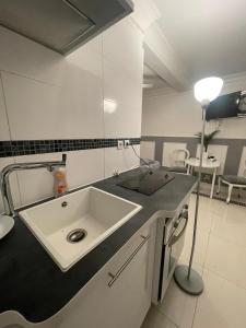 a bathroom with a sink and a lamp on a counter at Chambre de luxe 95 Grise in Deuil-la-Barre