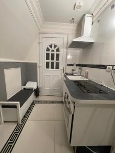 cocina blanca con fregadero y puerta en Chambre de luxe 95 Grise, en Deuil-la-Barre