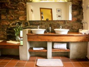 a bathroom with two sinks and a mirror at The Oil Mill Guesthouse in Swellendam