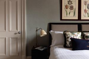 een slaapkamer met een bed met een lamp op een nachtkastje bij Links Townhouse in St Andrews