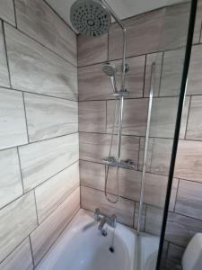 a bathroom with a shower and a bath tub at Cottage 5 minutes walk to river and town centre in Stratford-upon-Avon