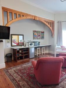 een woonkamer met een rode stoel en een tafel bij Dreamers Guesthouse - NO LOADSHEDDING in Koning Willemstad