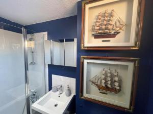 a bathroom with a picture of a boat on the wall at Stylish flat next to Tower of London and SKD marina in London