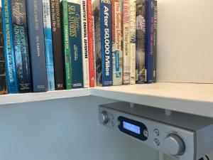 a row of books on a book shelf at Stylish flat next to Tower of London and SKD marina in London