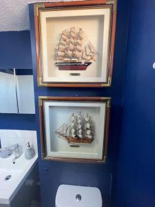 two framed pictures of a boat in a bathroom at Stylish flat next to Tower of London and SKD marina in London