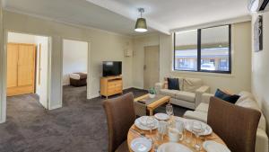 a living room with a couch and a table with chairs at New Crossing Place Motel in Seymour