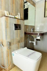 a bathroom with a toilet and a sink at Boshan Hotels in Mapusa