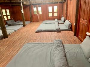 Habitación con 4 camas, suelo de madera y ventanas. en Green Sapa Homestay, en Sa Pa