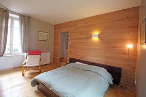 um quarto com uma cama e uma parede de madeira em Le gueraudier em Glandon
