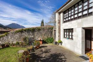 una casa con una pared de piedra y un patio en Casa rural El Cotero Lines, en Porrúa