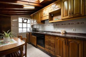 a kitchen with wooden cabinets and a table in it at Casa rural El Cotero Lines in Porrúa