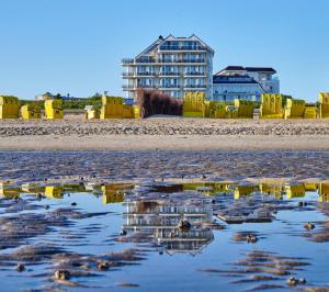 a reflection of a building on a beach at Badhotel Sternhagen in Cuxhaven