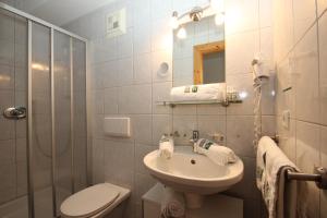 ein Bad mit einem Waschbecken, einem WC und einer Dusche in der Unterkunft Hoarachhof in Innsbruck
