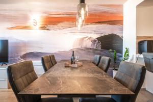uma sala de jantar com uma mesa e um quadro na parede em Apartment Bella em Zadar