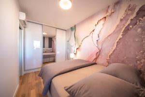 - une chambre avec 2 lits et une fresque murale dans l'établissement Apartment Bella, à Zadar