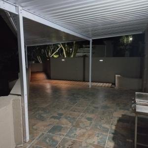 an outdoor patio with awning and a concrete floor at 8 On Eagle Self Catering Apartment in Umtentweni +2 photos