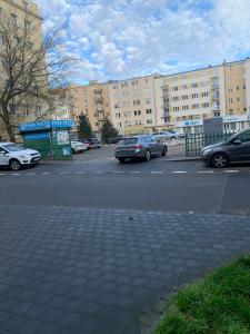un parking avec des voitures garées devant les bâtiments dans l'établissement Apartament 27, à Gdynia