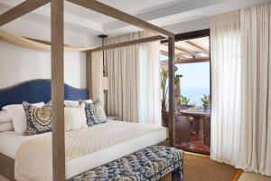 a bedroom with a four poster bed and a balcony at Marbella Club Hotel · Golf Resort & Spa in Marbella +37 photos