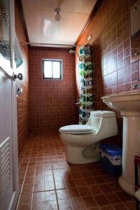 Charming 6-Bed House in Puerto Galera في بويرتو غاليرا: حمام مع مرحاض ومغسلة