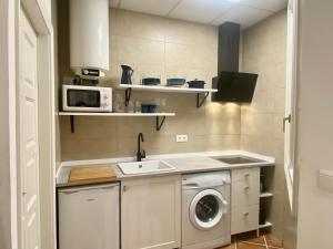 una pequeña cocina con fregadero y lavadora en Apartamento Puerta del Camino 1, en Bilbao