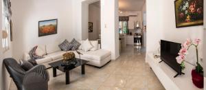 a living room with a white couch and a tv at Gogo's Cosy Beach House in Rethymno