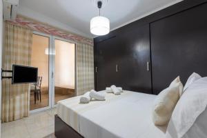 a bedroom with a large white bed with a black headboard at Gogo's Cosy Beach House in Rethymno