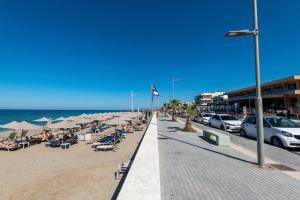 a beach with chairs and umbrellas and the ocean at Gogo's Cosy Beach House in Rethymno