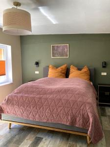 een slaapkamer met een groot bed met een paars dekbed bij Bungalow 314 in Joachimsthal