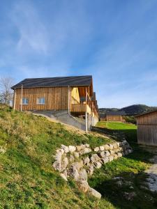 ein Haus auf einem Hügel mit einer Steinmauer in der Unterkunft Gites Jura Sud in Charchilla