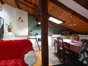 sala de estar con sofá rojo y cocina en El Quebrantahuesos, en Peralejos de las Truchas