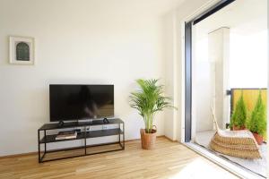 un soggiorno con TV a schermo piatto su un tavolo di Fine Studio with terrace - 15 Min to Center a Vienna