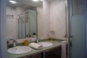 La salle de bains est pourvue de 2 lavabos et d'un miroir. dans l'établissement ROCH - Stylish Apartment near Metro, à Séville