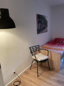 einen Stuhl und eine Lampe in einem Zimmer mit einem Bett in der Unterkunft Ferienwohnung Fenke in Fenke