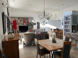 una cucina e un soggiorno con tavolo e sedie di Chambre d’hôte de Charme avec Piscine privative a Eyguières