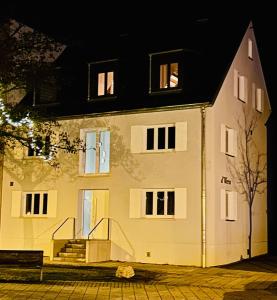 a large white building with windows at night at Anderswo Apartments in Langenau